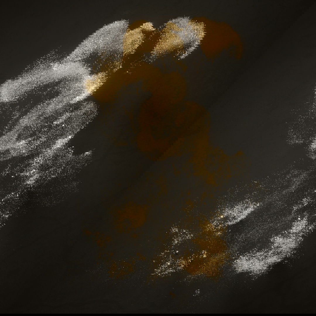 a teddy bear is sprinkled with powder on a black background